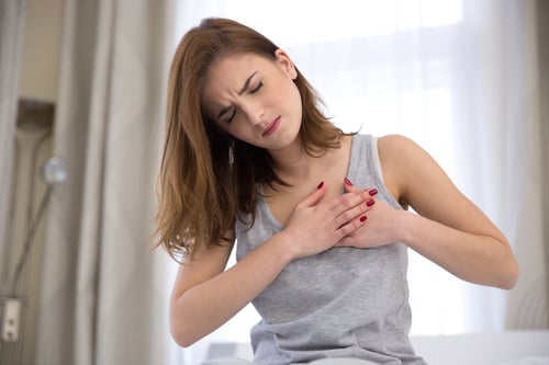 Young woman in pajamas having heart attack